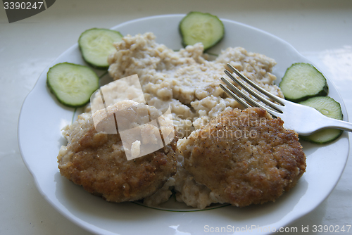 Image of Two meatballs, with porridge and cucumbers