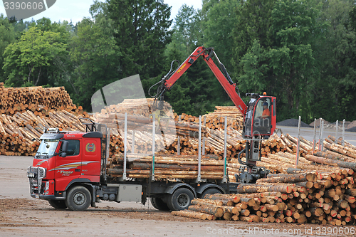 Image of Volvo FH Truck Unloads Logs at Lumber Yard