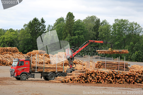 Image of Volvo FH Truck Unloads Logs at Lumber Yard