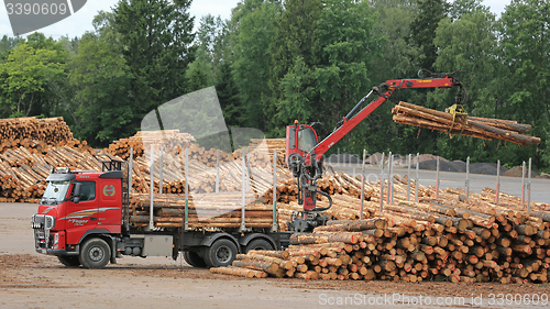 Image of Volvo FH Truck Unloads Logs at Lumber Yard