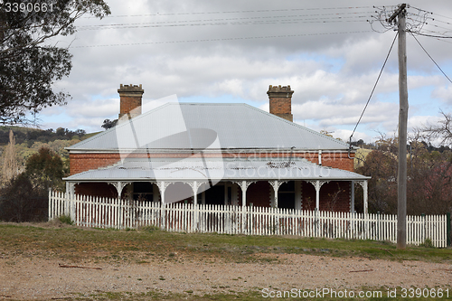 Image of Landscape scene with abandoned old house picket fence rural coun