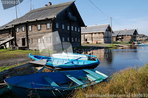 Image of wooden houses on the shore and  boats in fishing village