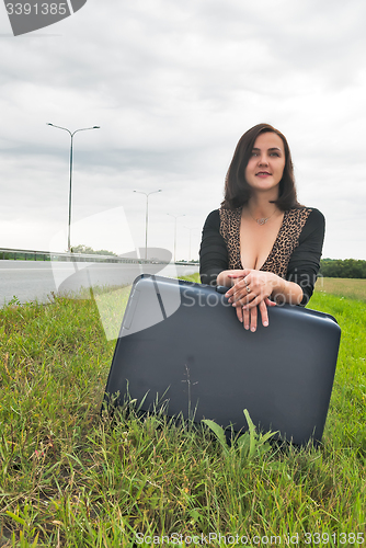 Image of Beautiful smiling woman with suitcase