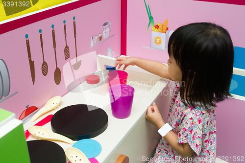 Image of Chinese children role-playing at kitchen
