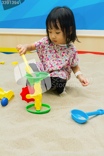 Image of Chinese children playing at indoor sandbox.