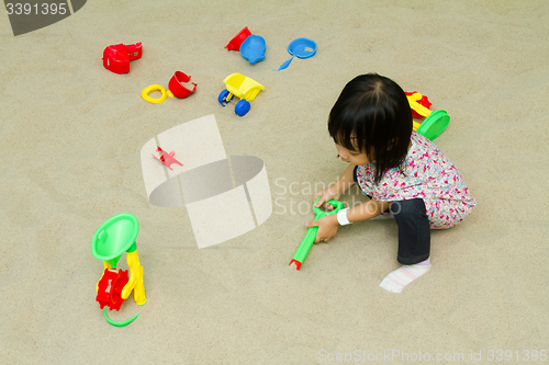 Image of Chinese children playing at indoor sandbox.