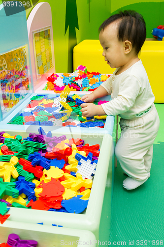 Image of Chinese baby playing puzzle