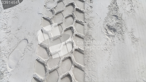 Image of Wheel track and footprints on the sand