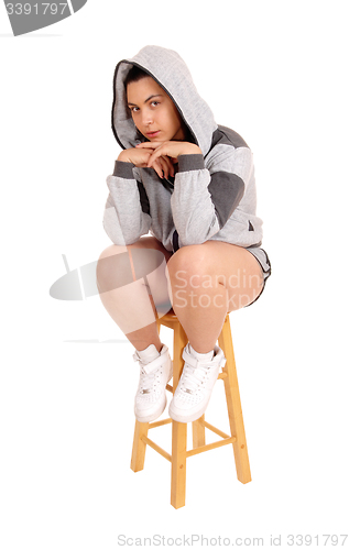 Image of Girl sitting on chair in gray hoodie.