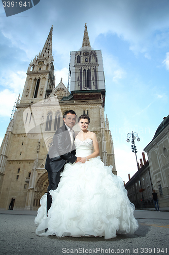 Image of Newlyweds holding hands in city