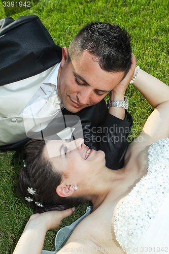 Image of Newlyweds on grass looking at each other