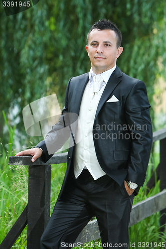Image of Groom posing in nature