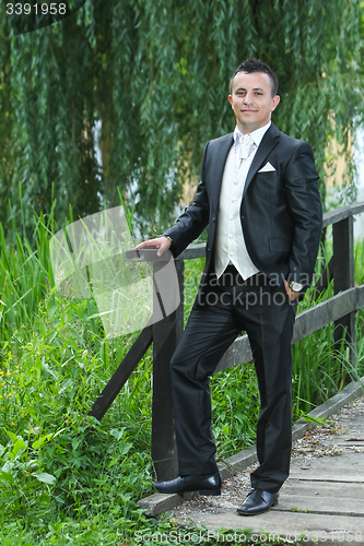Image of Groom on wooden bridge