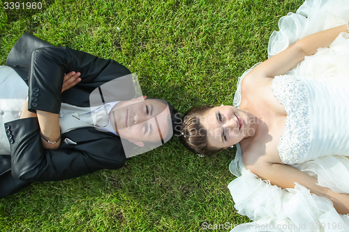 Image of Bride and groom posing on grass