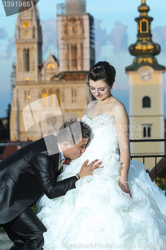 Image of Groom kissing bride on stomach