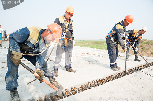 Image of Workers level plates for next filling by concrete