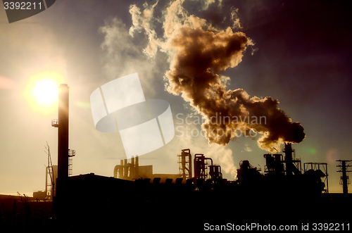 Image of Smoking chimney  at sunset 