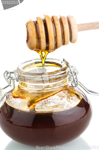 Image of Jar of honey with wooden drizzler