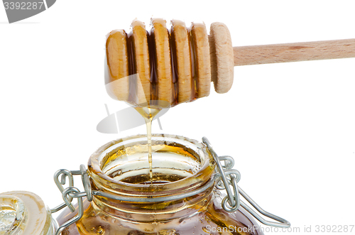 Image of Jar of honey with wooden drizzler