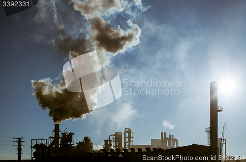 Image of Smoking chimney  at sunset 