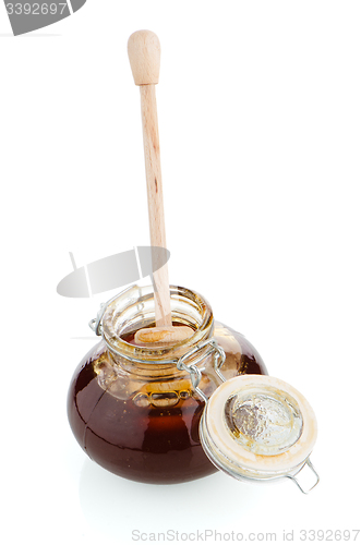 Image of Jar of honey with wooden drizzler