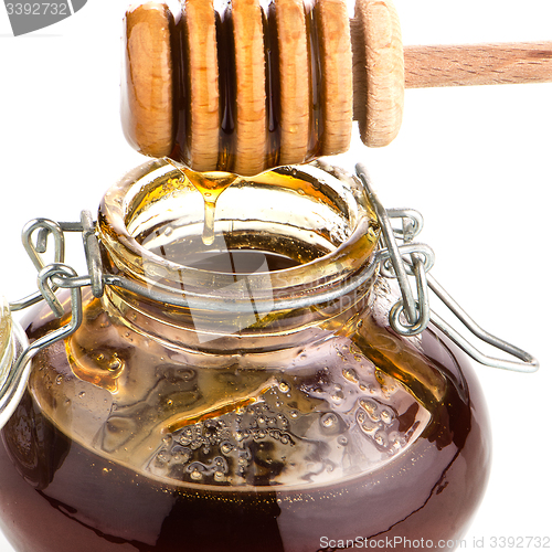 Image of Jar of honey with wooden drizzler