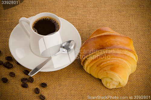 Image of Cup of black coffee and croissant 