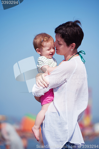 Image of mom and baby on beach  have fun