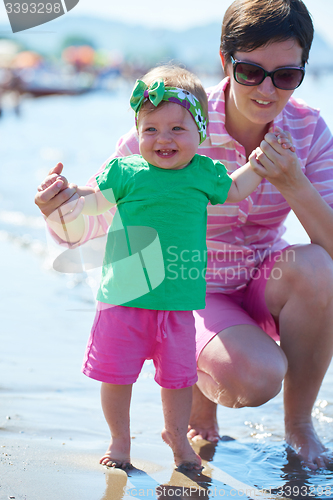 Image of mom and baby on beach  have fun