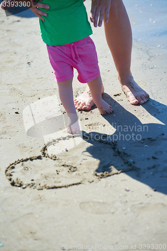 Image of mom and baby on beach  have fun