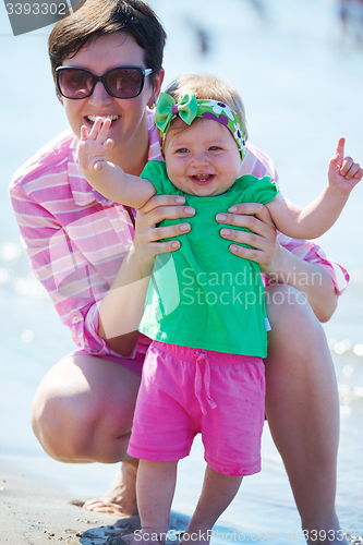 Image of mom and baby on beach  have fun