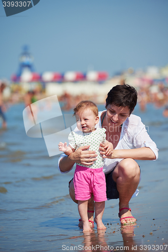 Image of mom and baby on beach  have fun