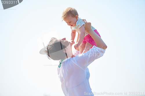 Image of mom and baby on beach  have fun