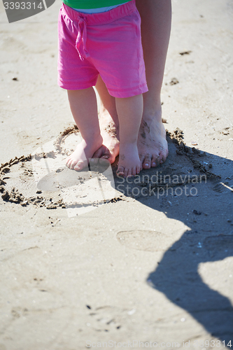 Image of mom and baby on beach  have fun