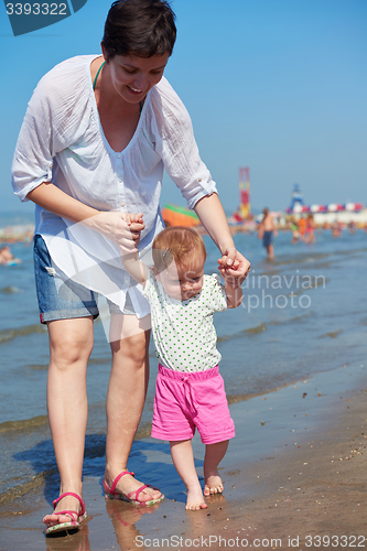 Image of mom and baby on beach  have fun