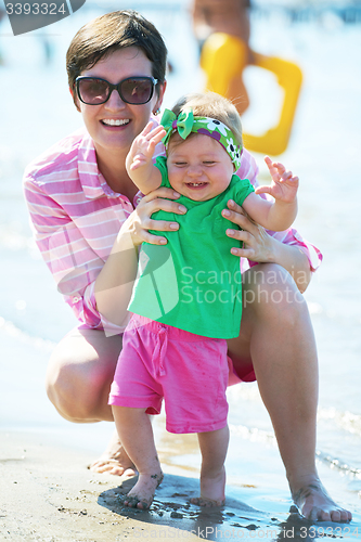 Image of mom and baby on beach  have fun