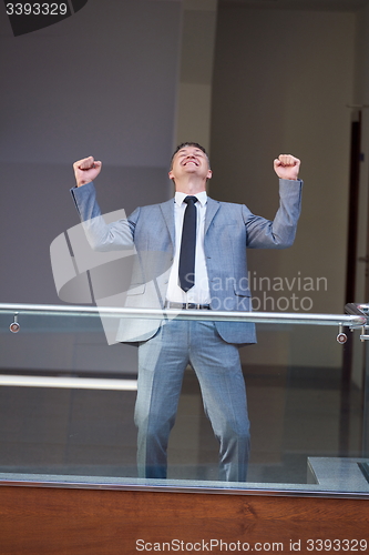 Image of happy business man raise hands from joy