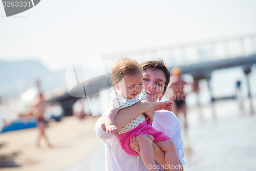 Image of mom and baby on beach  have fun