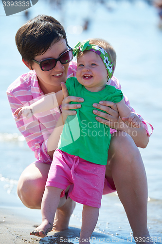 Image of mom and baby on beach  have fun