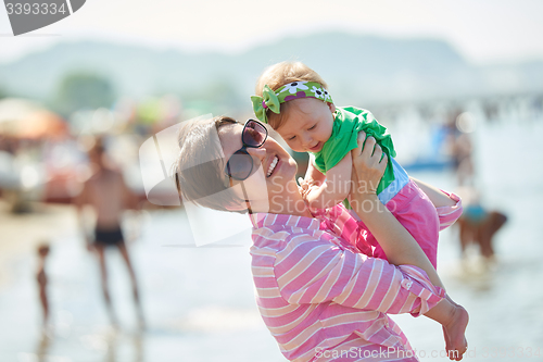 Image of mom and baby on beach  have fun