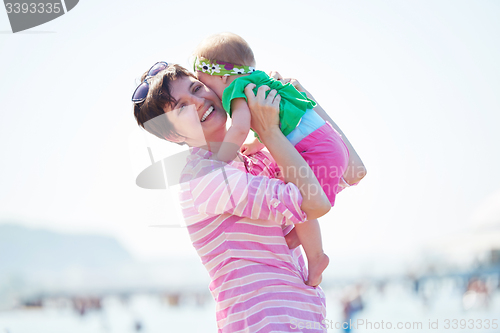 Image of mom and baby on beach  have fun