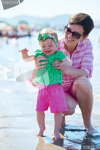 Image of mom and baby on beach  have fun