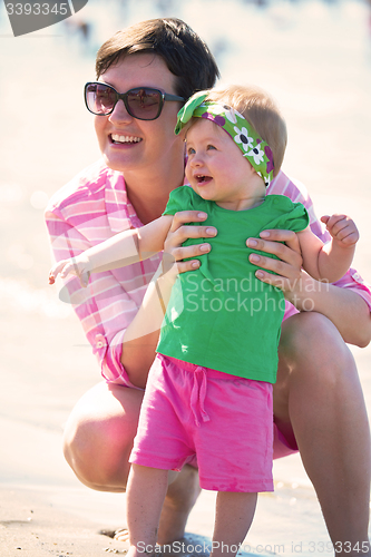 Image of mom and baby on beach  have fun