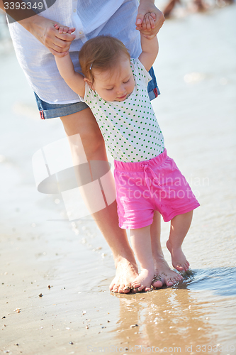 Image of mom and baby on beach  have fun