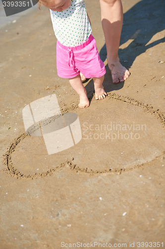 Image of mom and baby on beach  have fun