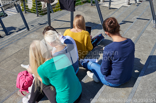 Image of students outside sitting on steps