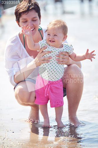 Image of mom and baby on beach  have fun