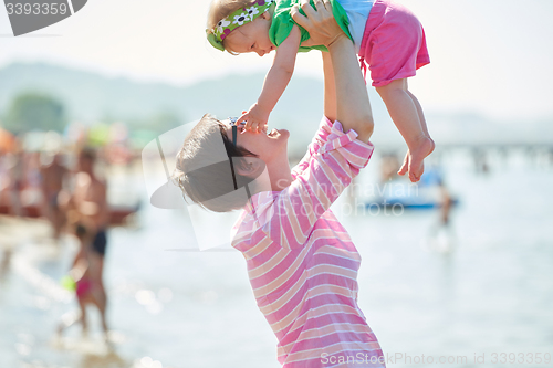 Image of mom and baby on beach  have fun