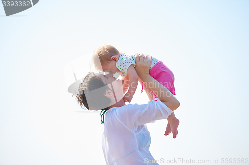 Image of mom and baby on beach  have fun