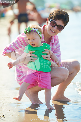 Image of mom and baby on beach  have fun